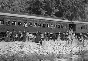 passangers wait alongside a train